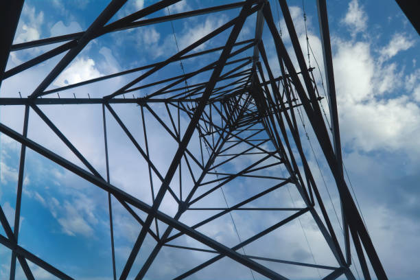 istock Power poles transmission line, Electricity high voltage pole, Electrical network. Bottom up view 1222334293