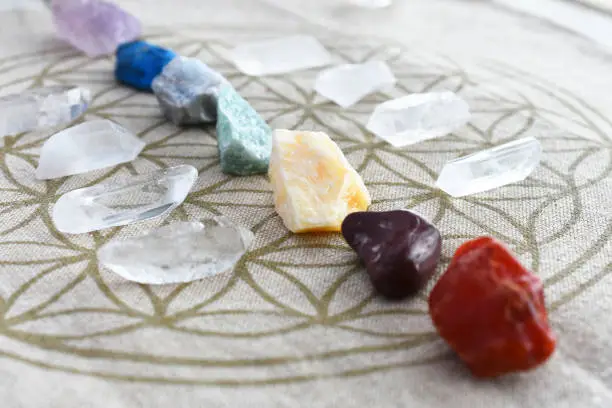 A close up image of chakra balancing crystals on a sacred geometry grid cloth.