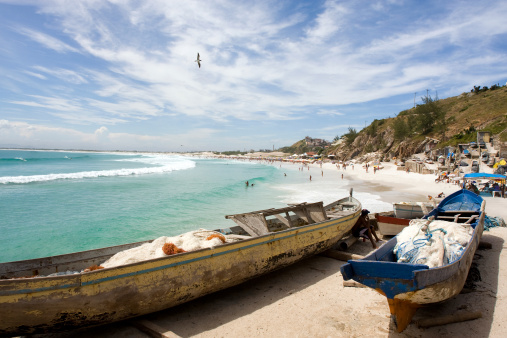 Small fishing boats with their fish nets on the sands of a beautiful beach in the village of Arraial do Cabo, Rio de Janeiro, Brazil.