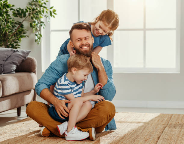 istock Happy dad and kids embracing at home 1222340544