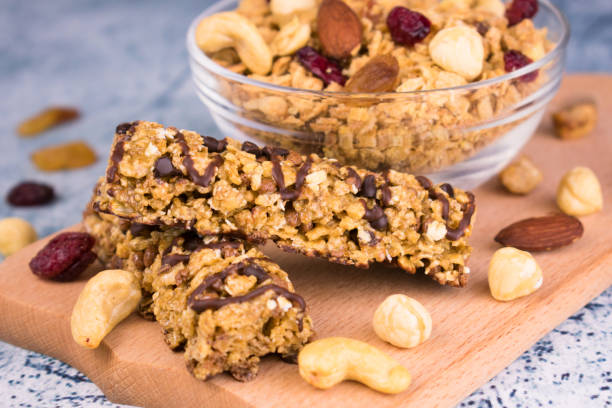 bol de granola avec des noix et des barres de granola en gros plan. concept de petit déjeuner sain. - bran flakes photos et images de collection