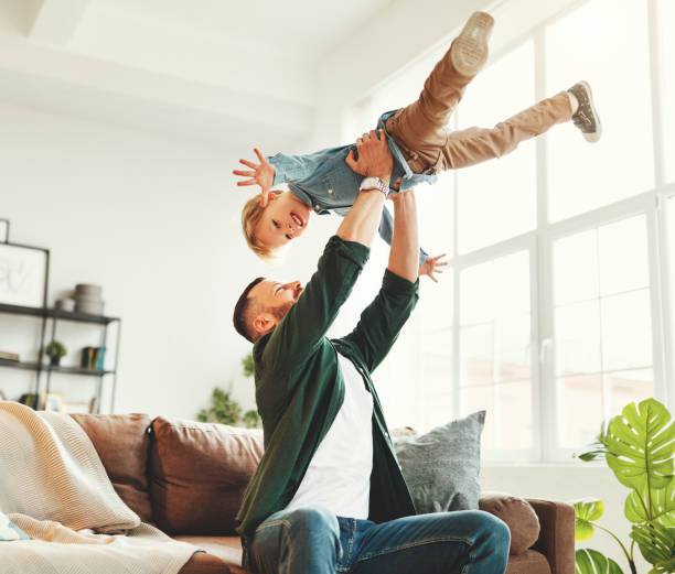 istock Happy man having fun with son at home 1222341362