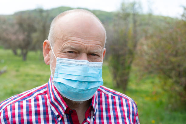 istock Senior man with surgical mask outdoors 1222344519