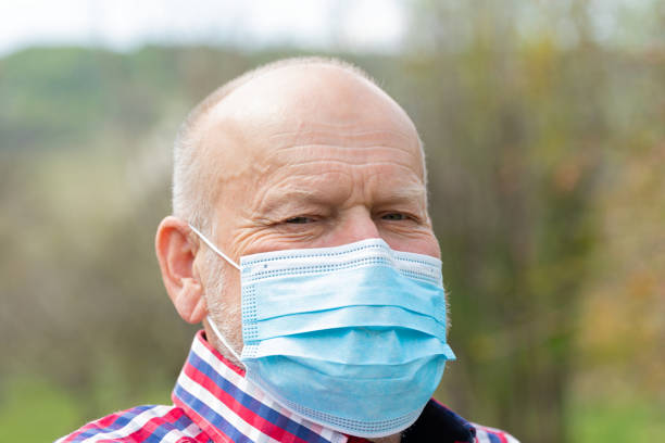 istock Senior man with surgical mask outdoors 1222344530