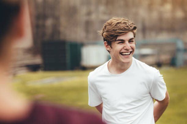 junge lächelnd während des körperlichen trainings in der high school - männlicher teenager stock-fotos und bilder