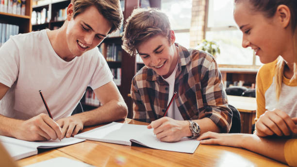 istock Happy young friends working on high school project 1222348137