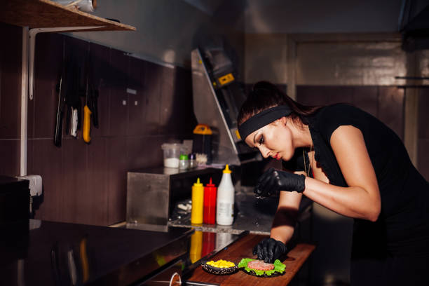 istock woman chef in the kitchen preparing a hamburger sandwich 1222350010