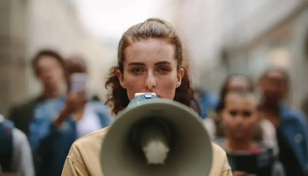 Photo of Female activist protesting with megaphone during a strike