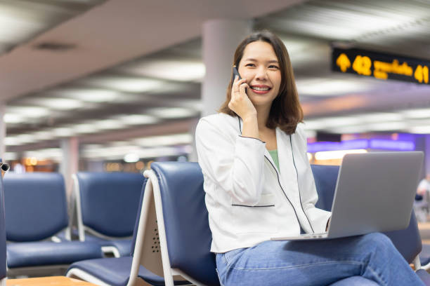 istock close up businesswoman talking with partner or vendor on smartphone and using laptop while seated to waiting boarding time from airline for business meeting concept 1222352784