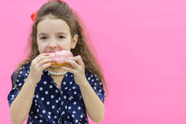 istock A model holding a glazed donut in hands. 1222354504