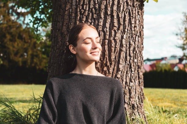 jeune femme appréciant le soleil dans le jardin - relaxation eyes closed women photography photos et images de collection