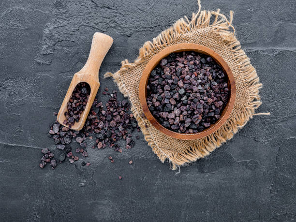istock Himalayan black salt and Himalayan pink salt on dark concrete background. Himalayan salt commonly used in cooking and for bath products such as bath salts. 1222364339