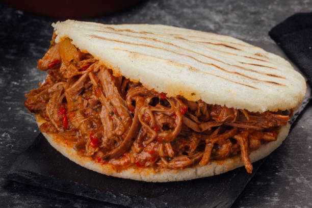 istock Arepa stuffed with shredded meat on a dark background. (Arepa con carne mechada) 1222367073