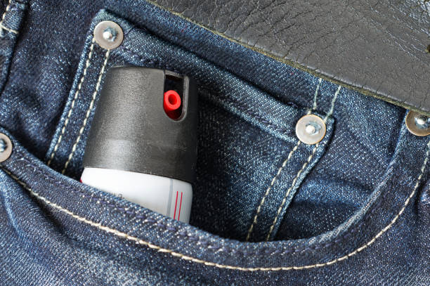 gas lacrimógeno o gas pimienta en el bolsillo de los jeans. herramienta de autodefensa. - pulverizador de pimienta fotografías e imágenes de stock