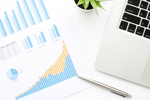 istock White office desk table with business charts document, laptop computer and supplies. Top view, flat lay image. 1222369264
