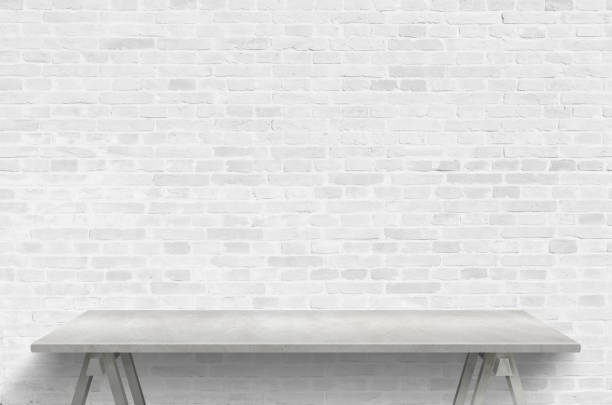 istock Empty gray desk and brick wall for producrt presentation. Free space for promo text 1222371129
