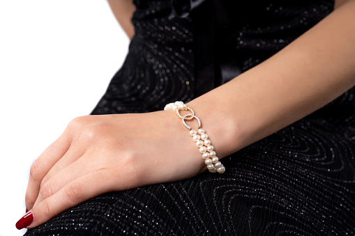 woman wearing pearl diamond wristband on white background