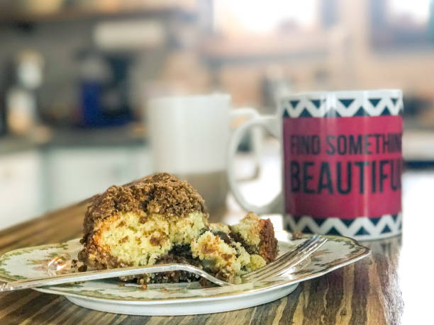 Slice of coffee cake on a plate with a coffee mug
