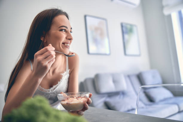 istock Smiling lady enjoying her meal at home 1222384220