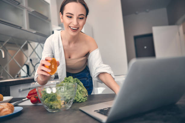 istock Caucasian charming lady cutting vegetables on board at home 1222384370