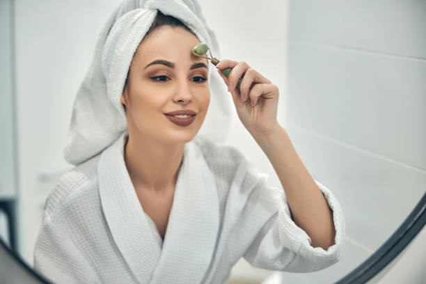 istock Caucasian cute lady doing face massage opposite mirror indoors 1222384921