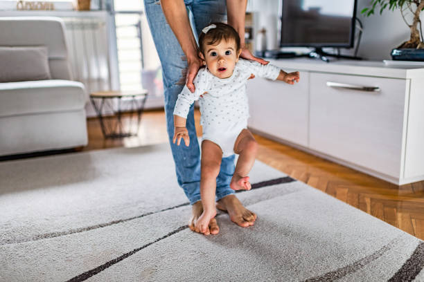 istock First steps of baby with the help of mom 1222385121