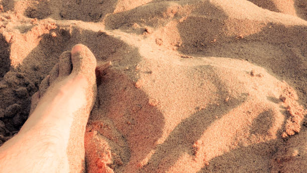 istock male feet covered in sand on the beach in sunlight 1222385264