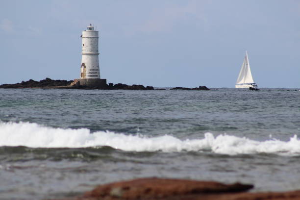 istock Lighthouse and sailboat - Calasetta Sardinia 1222386190