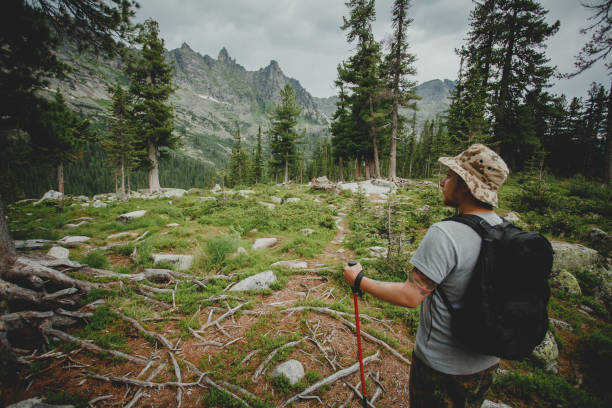 istock Man hiking in mountains with backpack in wildlife nature 1222386540