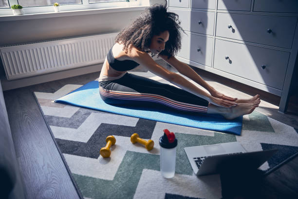 istock Concentrated curly haired woman stretching her body 1222387759