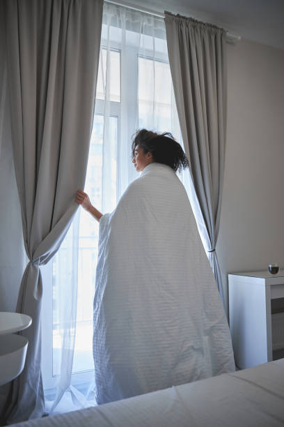 istock Relaxed curly haired female person looking at window 1222387814