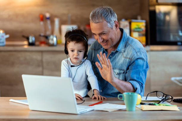 Happy mature father and kid son making video call