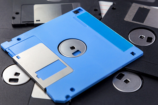 Blue and black 3.5 inch floppy disks as background.