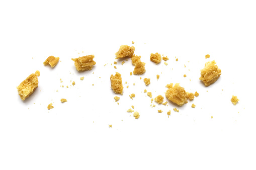 Scattered crumbs of butter cookies on white background.