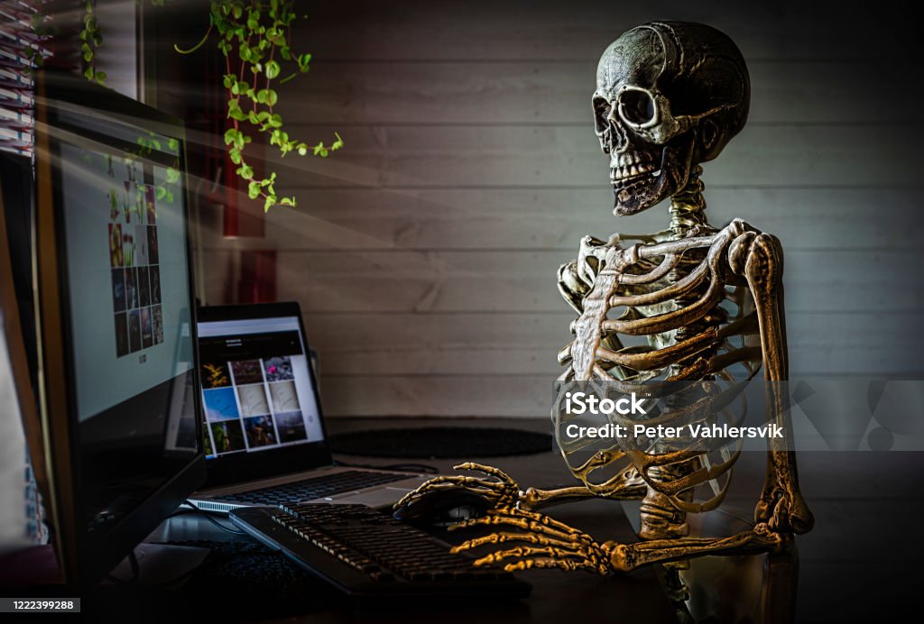 Human skeleton at office Skeleton at office desk, worked to hard. Spooky feeling.

Images on computers in the picture i my own, those are at my website. Halloween Stock Photo