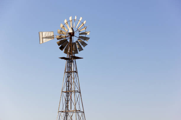 istock Rusty metal windmill at sunset over blue sky background 1222401768