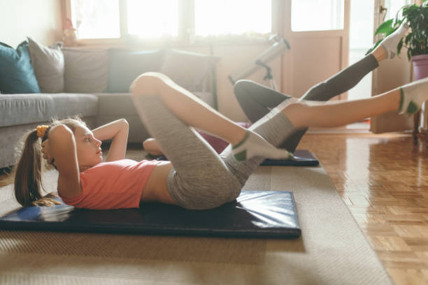 istock Mother and daughter exercising at home 1222403621