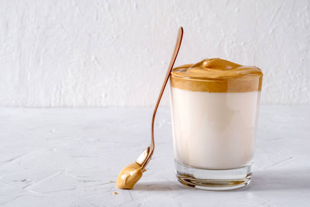Dalgona Coffee. Milk topped with whipped instant coffee.