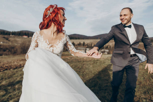 istock rustic wedding couple running and having fun in mountains in sunset light. space for text. happy stylish bride and groom laughing, true feelings. emotional romantic moment. space for text 1222404348