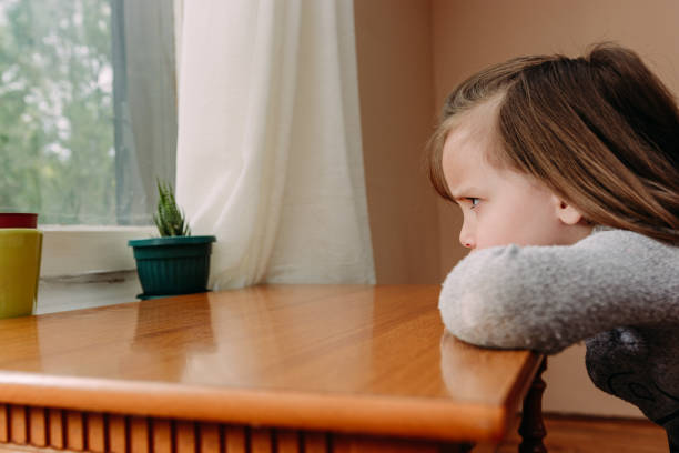 istock Sad child girl by the window 1222406799