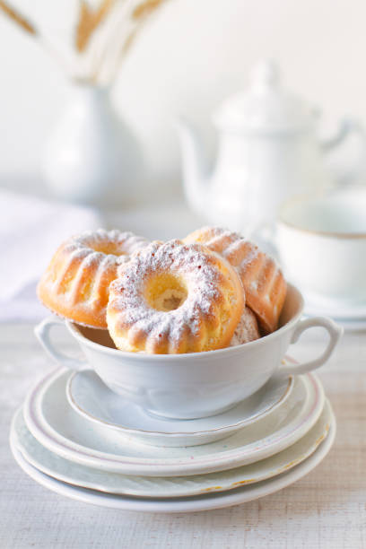 mini tortas bundt con azúcar glas en una pila de platos blancos - chocolate bundt cake fotografías e imágenes de stock