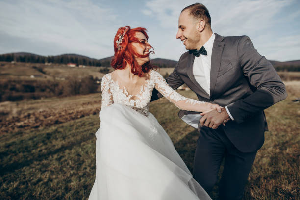 istock rustic wedding couple running and having fun in mountains in sunset light. space for text. happy stylish bride and groom laughing, true feelings. emotional romantic moment. space for text 1222408634