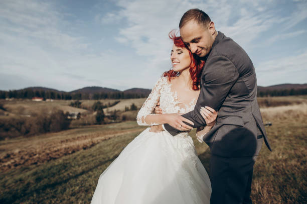 istock rustic wedding couple hugging and smiling in mountains in sunset light. space for text. happy stylish bride and groom having fun and embracing. emotional romantic moment. space for text 1222408791