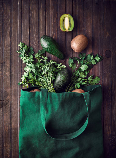 доставка покупок в интернете. экологически чистый мешок с авокадо, киви и зеленью на коричневом деревянном фоне - 3666 стоковые фото и изображения