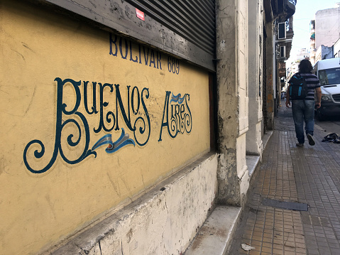 Buenos Aires, Argentina - February 15, 2019: Man walking over narrow sidewalk in the old part of the city. This area is very popular amongst tourist for its cultural and entertainment offers