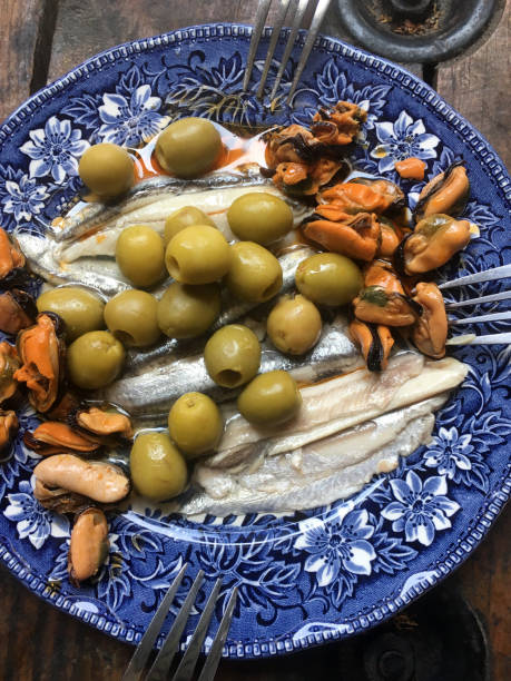 Blue dish with green olives and seafood