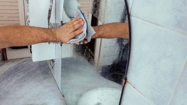 istock Cheerful man cleaning bathroom mirror 1222412322