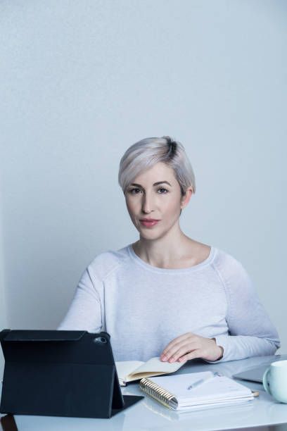 istock girl working at home with a tablet while writing in a notebook and smiling on a white background 1222412592