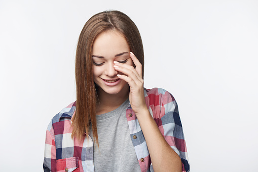 Teen girl laughing to tears, studio portrait