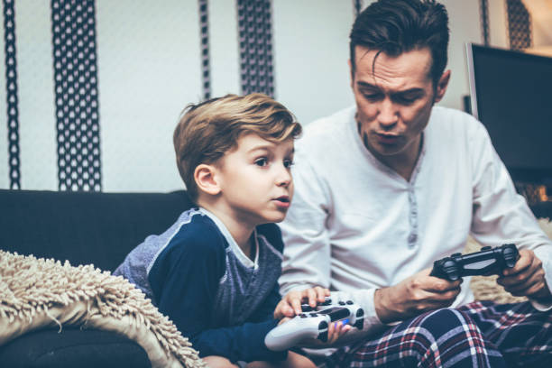 istock Father and son talking while playing video games at home. 1222416572